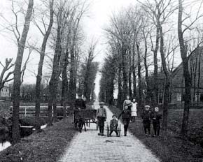Op de Oosterboekelweg van het kerkdorp De Weere staat rond 1910 bakker Beemster met z'n hondenkar en enkele kinderen.
