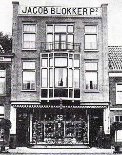 Jacob Blokker staat op deze foto uit omstreeks 1920 in de deuropening van zijn zaak.
