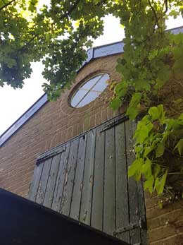 Het ronde raam en de deur in de noordgevel.