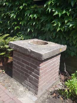 Naast de schuur staat een waterput.