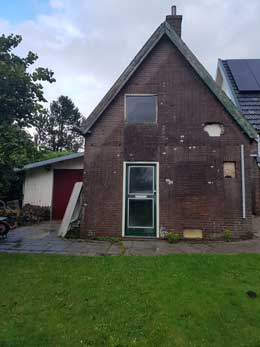 De achterzijde met de contouren van een dichtgemetselde deur bovenaan.