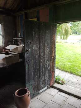 Treed binnen in de oudste schuur, gemaakt van hergebruikte planken e.d.