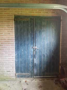 Deur in de overkapping die toegang biedt tot de schuur.