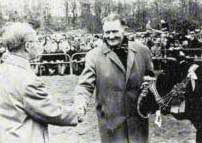 Op de centrale stierenkeuring 1975 in Alkmaar ontvangt Gerrit Stapel de kampioensrozet voor zijn Pan 235.