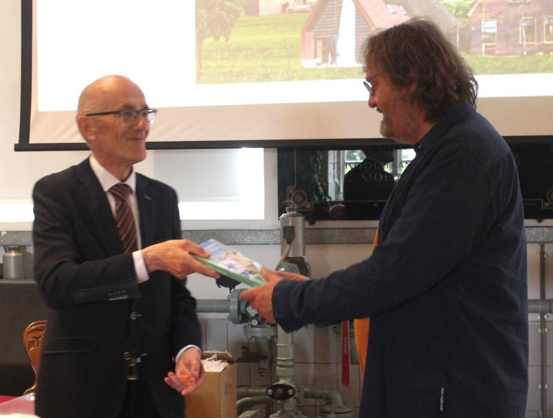 Voorzitter Jan Smit van het Westfries Genootschap overhandigt stolpenarchitect Maarten Koning het eerste exemplaar van het nieuwe jaarboek. (foto Stichting Projector/Kees Kreuk)