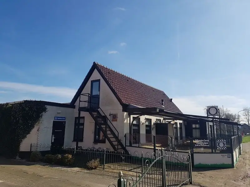 Het caf&eacute; met het openbare toilet en het deels overdekte terras.