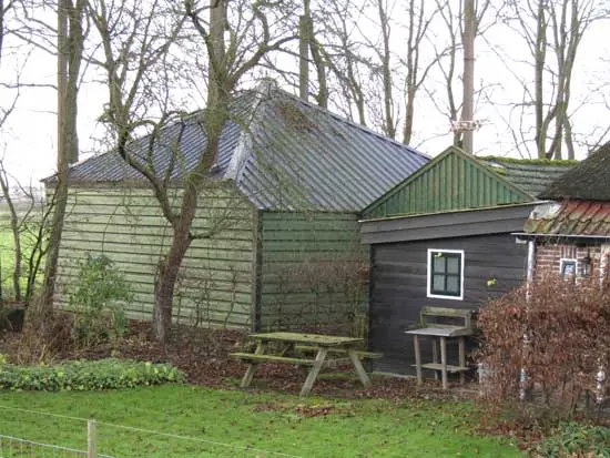 Hooivijzel naast een boerderij.