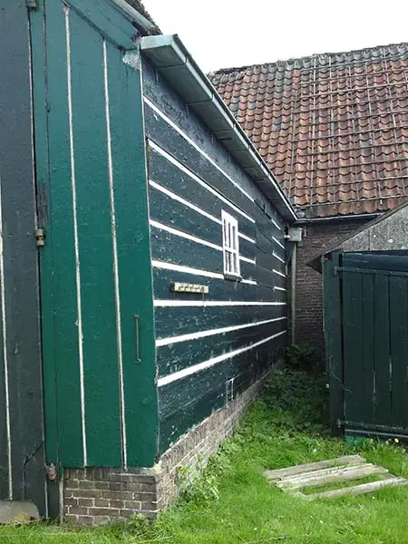 Gepotdekselde wand achter met links een stukje van de darsdeur.