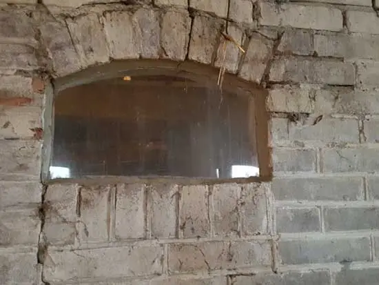 Koeraam in de muur tussen boerderij en schuur.