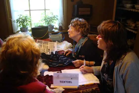 Textiel wordt bekeken: Tineke Waal beoordeelt textiel.