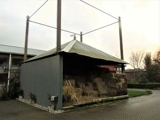 Aan &eacute;&eacute;n kant is enige tijd geleden een wand geplaatst als bescherming tegen wind en regen.