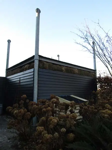 Nieuw gebouwde hooivijzel met ronde stalen palen en bovenaan een rand hooi.
