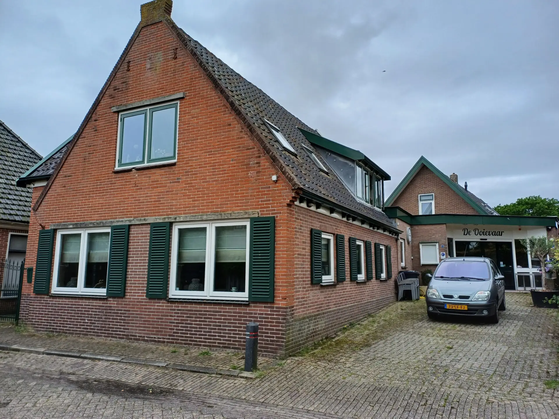 Warmenhuizen de woning met rechts de ingang van De Ooievaar