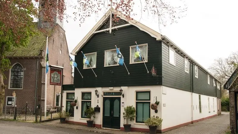 Het caf&eacute; in 2023. De vlaggen wapperen nog maar de deuren zijn dicht. Foto Dick Ham, Stichting Projector.