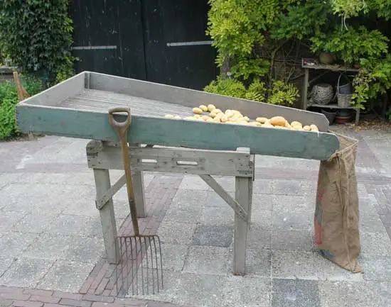 De hort met aardappels en daarvoor een greep.
