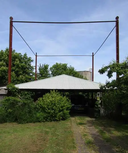 De hooivijzel met ijzeren roeden, geplaatst achter het huis.