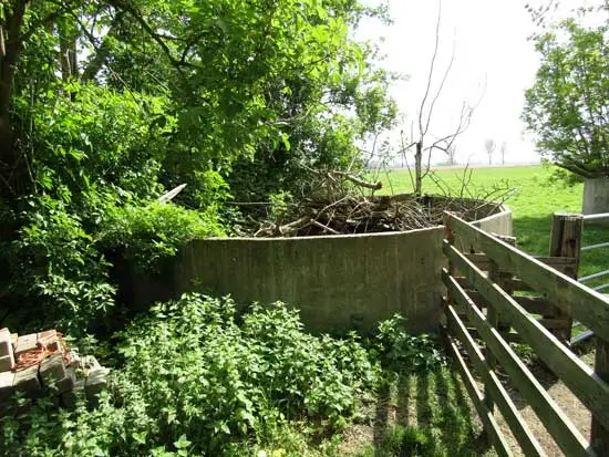 Twee silo's op het erf met begroeiing