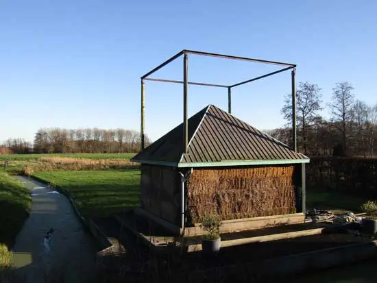 Hooivijzel, gevuld met balen, met ronde ijzeren staanders maar zonder vijzelmogelijkheid en windvaan.
