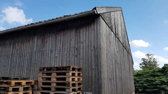 Zij- en achterkant van de houtloods.