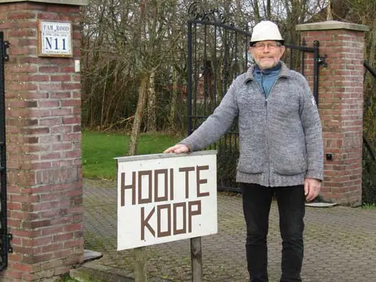Jaap Rood bij het bord dat aan de weg staat.