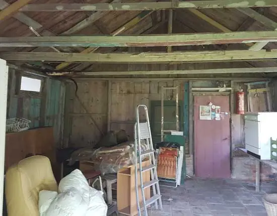 Interieur eerste schuur met dakconstructie. Goed te zien is dat de wanden uit veel verschillende planken bestaan.