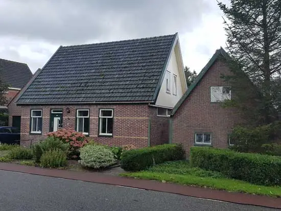 Huis en schuur anno 2020 met twee kleine ramen in de voorgevel. Het dak van de woning is verhoogd.
