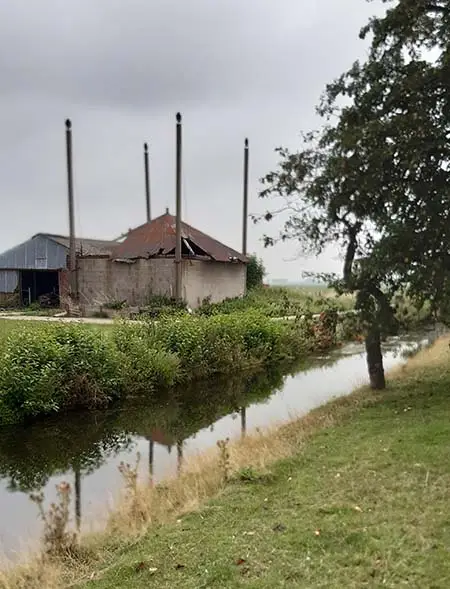 Links de schuur. Goed te zien is dat deze vijzel een eind van de weg af staat.