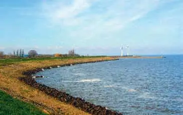 De Oosterdijk gezien vanaf vuurtoren De Ven richting de waterzuiveringinstallatie bij Andijk. (Foto TM)