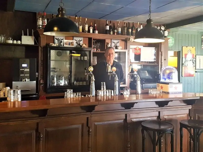Co Scholten achter de tap.