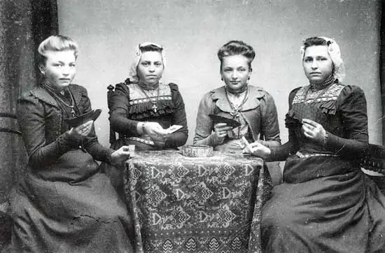 Op deze foto van omstreeks 1900 leggen vier meisjes uit Schellinkhout een kaartje.