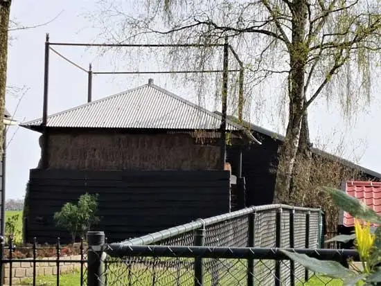 De vijzel is omtimmerd met planken (gepotdekseld) en bovenaan liggen een aantal lagen hooibalen.
