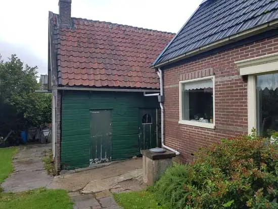 De zijkant van de schuur is van hout.