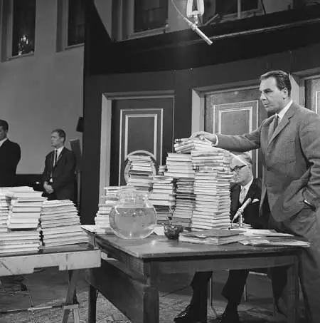 Fred. Groot als Ewout Speelman met Willem Duys achter stapels van zijn boeken...