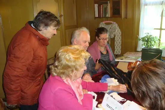 Textiel wordt bekeken: Sarah Kalis uit Schagen (met bril) is gevraagd textiel te bekijken.