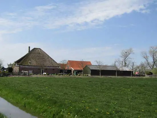 Kijkje op de boerderij met schuren en daarachter de vijzel.